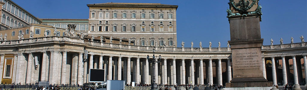 Base de l'obélisque du Vatican, siégeant fièrement au centre de la grande Place Saint-Pierre, sous un ciel serein.