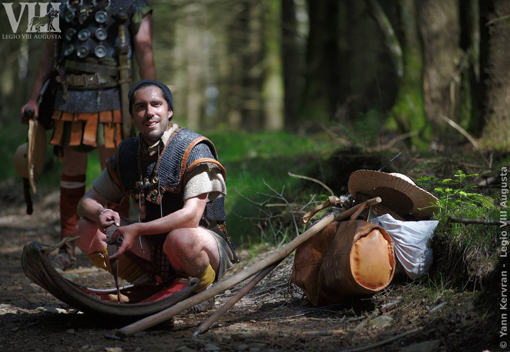 Une petite pause pour réparer une sangle de bouclier, après plusieurs heures à marcher, avec tout l'équipement d'un légionnaire romain.